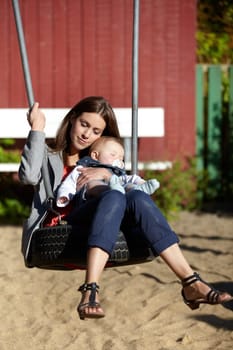 Woman, baby and swing on park for love, bonding and play with sunshine, child development and care. Mother, kid and infant swinging outdoor in summer for fun, enjoyment and nurture with happiness