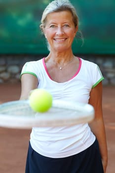 Mature, woman and portrait smile for tennis racket on court or ball play, retirement workout or match ready. Female person, face and fun or exercise bat for health mobility, training sport or proud