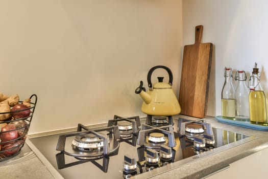 a kitchen with a stove with a yellow kettle
