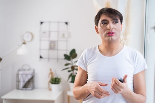 The man is wearing makeup. Transgender posing in the studio.