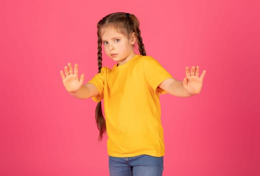 Scared Little Girl Showing Stop Gesture With Hands And Looking At Camera