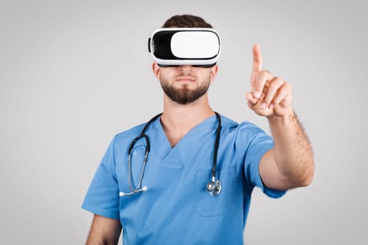 Young doctor man in blue scrubs engaging with virtual reality