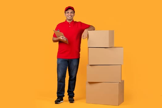 delivery man leaning on cardboard parcels boxes stack in studio