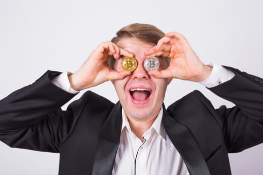Crazy bitcoin lover with golden and silver coins by eyes, funny miner with coins.