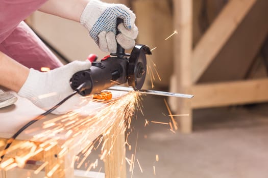 Worker Using Angle Grinder in Factory and throwing sparks.
