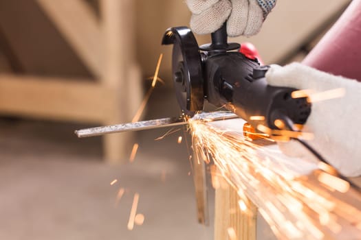 Worker Using Angle Grinder in Factory and throwing sparks.