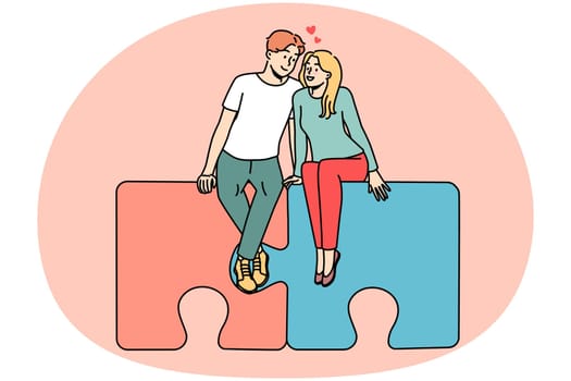Happy couple sitting on connected puzzles