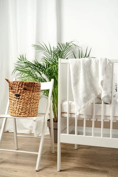 Baby bed and basket in nursery room interior