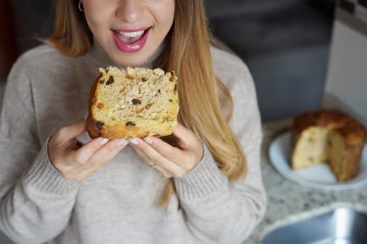 Unrecognizable girl eating a slice of Panettone traditional Christmas cake 