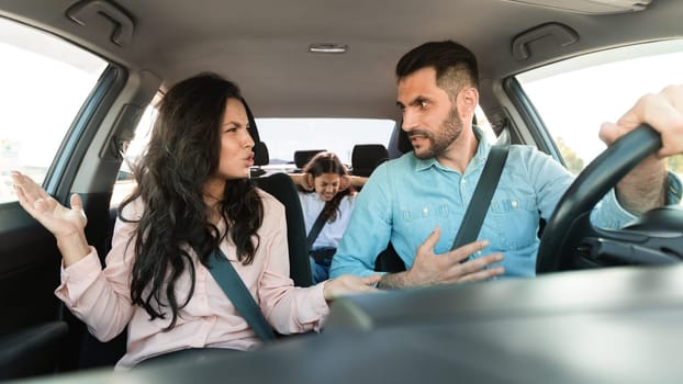 Caucasian couple arguing in car, distressed child in backseat