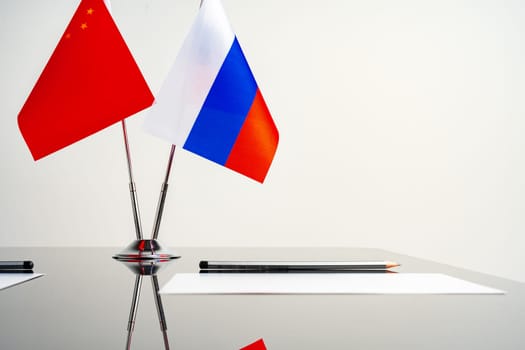 Russian and Chinese flags on negotiation table