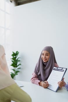 Muslim female employee Hold important documents and discuss agreements with customers.