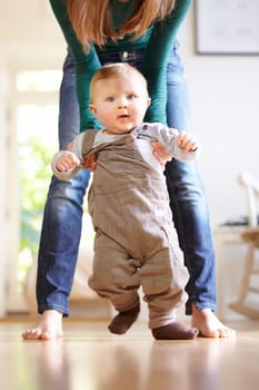 Mother, baby and face with help for walking in home for motor skills, development or milestone with assistance. Son, toddler and excited for mobility, movement or freedom in living room with support