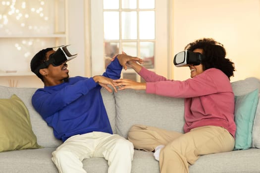 Black young couple experiencing fun and interactive VR simulations indoors