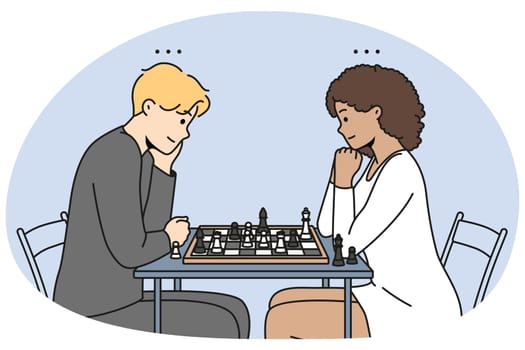 Couple sit at table playing chess