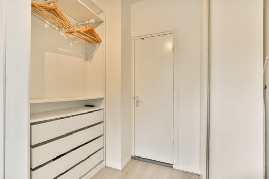 a closet with white cabinets and a white closet door