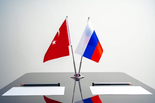 Flags of Turkey and Russia on poles on negotiation table