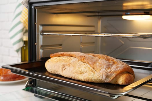 Freshly baked bread in mini oven in the kitchen