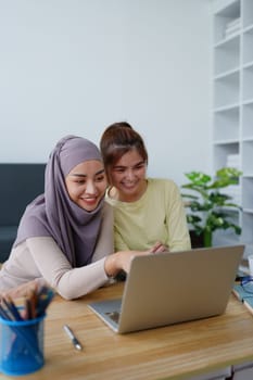 Muslim undergraduates and Asian women are studying online using computers.