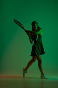 Tennis player with racket in sportswear. Woman athlete playing at studio background.