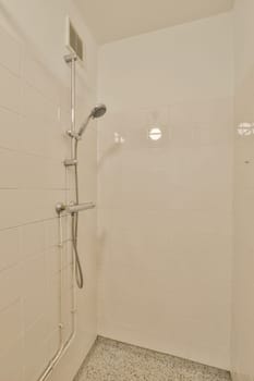 a white shower in a white tiled bathroom