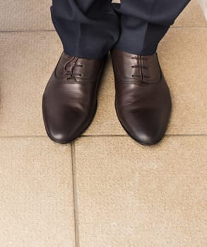 Close-up of businessman feet in black boots on the floor.