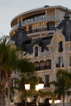 Monaco, Monte-Carlo, 12 November 2022: The famous hotel de Paris is at dusk, square of Casino Monte-Carlo, attraction night illumination, luxury cars, players, tourists, splashes of fountain