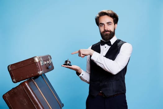 Male bellhop with suitcases and bell