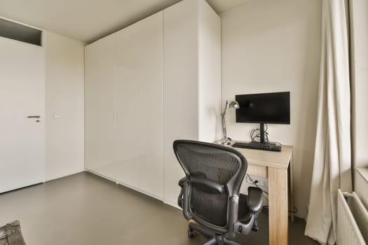 a room with a desk and chair and a computer