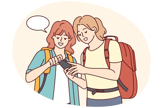 Smiling female travelers using cellphone
