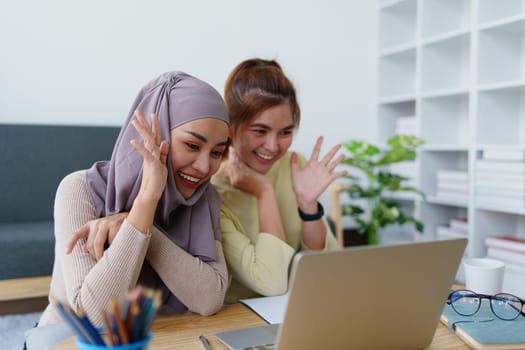 Muslim undergraduates and Asian women are studying online using computers.