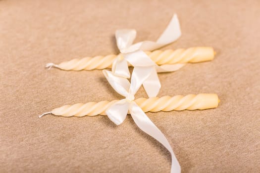 Two white candles with ribbons