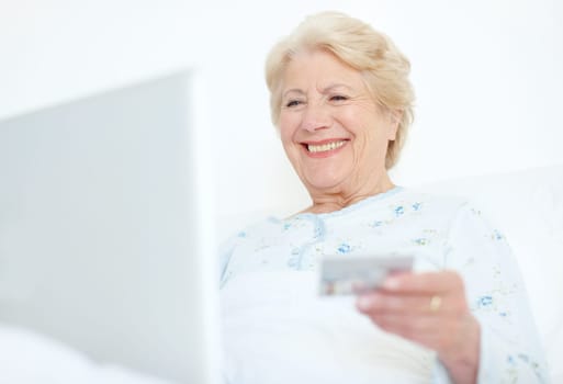 Keeping up with payments is a weight off her shoulders. Elderly hospital patient prepares to make a purchase off of the internet with her credit card.