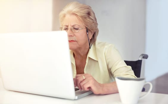 Shes one tech-savvy old lady. a senior woman using her laptop at home.