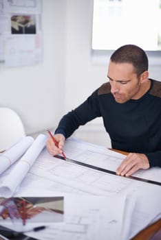 He takes great pride in the accuracy of his work. an architect drafting up building plans.