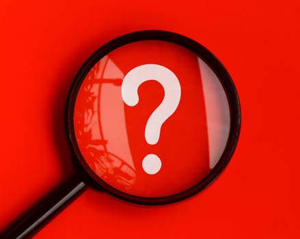Question mark on red background with magnifying glass. Question and Answer session.