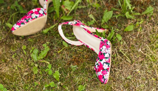 Shoes of a woman on green grass. Summer holiday concept, daylight