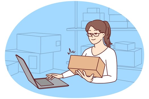 Woman working on laptop at warehouse