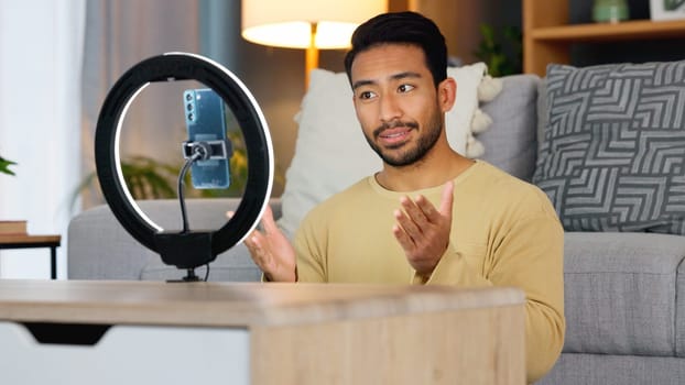 Influencer man, phone and ring light for live stream, web chat or recording in home living room. Content creator guy, video call or vlogger on smartphone, contact or communication in lounge at house