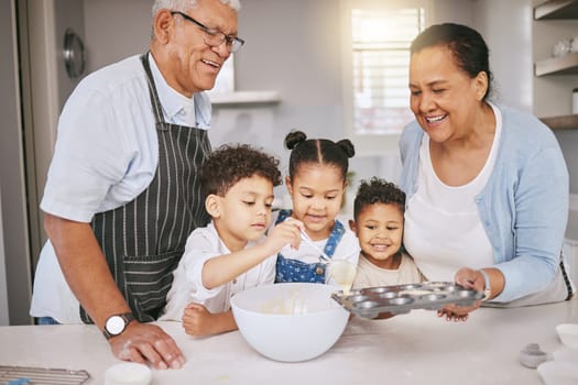 Each on gets a turn. a mature couple baking with their grandkids at home.