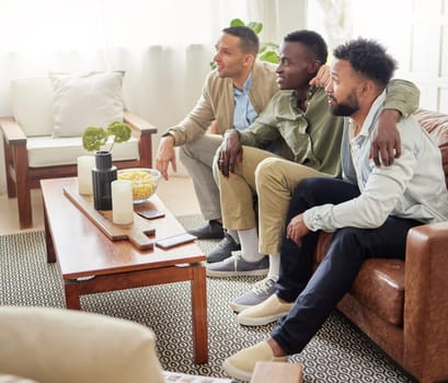 Our team has better luck when we watch the match together. three male friends watching something together while sitting on a couch.