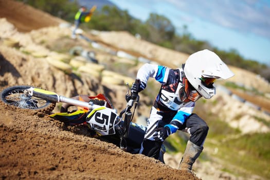 Accident, fitness and man biker on a dirt road for competition, race or training workout. Sports, motorcycle and frustrated male athlete with mistake on bike in outdoor sand dunes or desert for hobby.