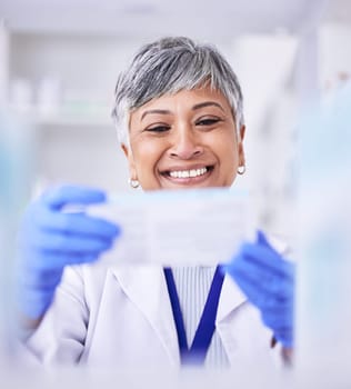 Pharmacist, mature woman and medicine box for prescription at pharmacy with blurry background. Healthcare, drugstore and pharmaceutical worker holding tablet or treatment in closeup at clinic.