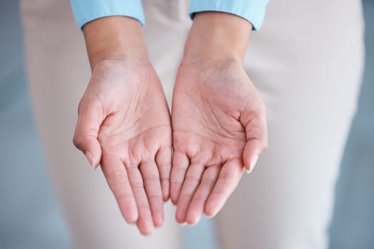 Above view and closeup of two hands extended with open palms in a giving and receiving gesture. Unknown mixed race businesswoman asking for help. Hispanic office professional offering support