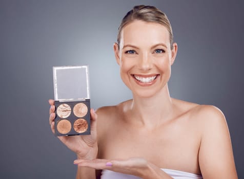 Makeup pallet, woman in portrait and beauty with cosmetics product, foundation and eye powder on studio background. Smile, cosmetic care and cosmetology, eyeshadow or blush, mockup and advertising