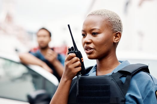 Black woman, police and walkie talkie for radio in city communication, reinforcement or emergency. African female person, security guard or cop calling backup for crime on patrol in urban town street