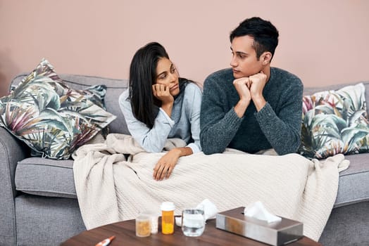 Self quarantine can lead to feelings of stagnation. a young couple sitting on the sofa while recovering from an illness at home.