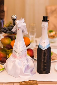 Champagne bottles decorated as a bride and groom