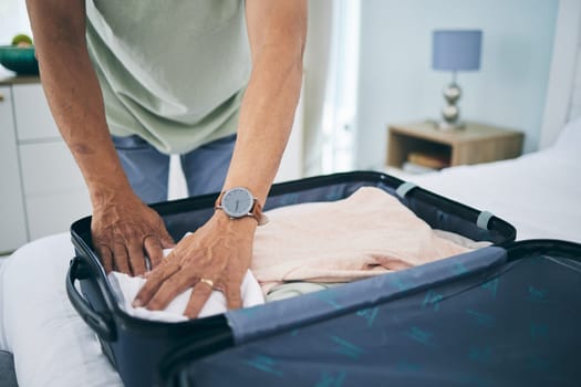 Man, hands and packing suitcase in home for travel, holiday trip and vacation. Closeup, person in bedroom and prepare clothes in luggage bag for journey, solo adventure and leaving for tourism voyage