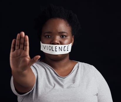 Portrait, hand and a black woman in protest of domestic violence on a dark background. Freedom, equality or empowerment with the palm of a serious young person in studio for gender discrimination